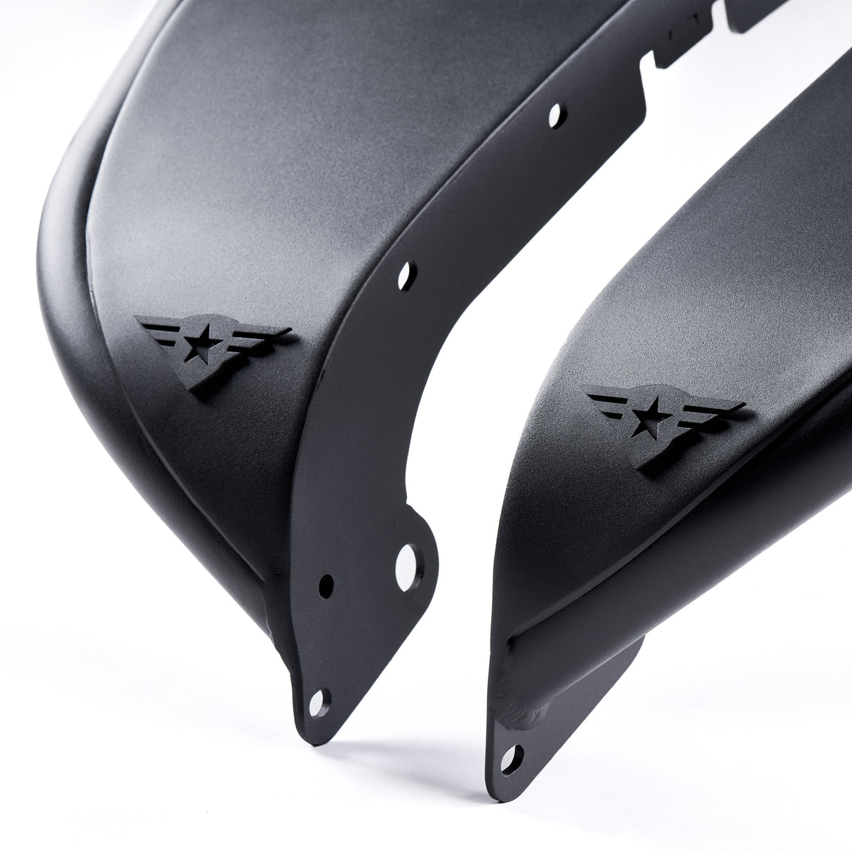 Close-up view of two front black aluminum fender flares for Jeep Wranglers, featuring a textured powder-coated finish. Each fender flare includes a removable and paintable Combat Off Road logo near the edge, along with pre-drilled holes for easy installation. Built for durability and customization, these fender flares are ideal for off-road performance and style.