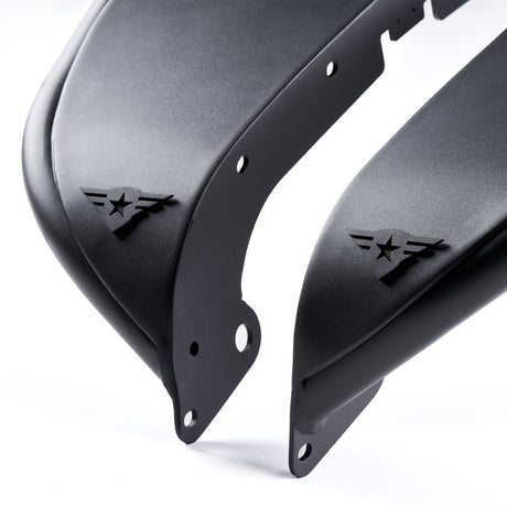 Close-up view of two front black aluminum fender flares for Jeep Wranglers, featuring a textured powder-coated finish. Each fender flare includes a removable and paintable Combat Off Road logo near the edge, along with pre-drilled holes for easy installation. Built for durability and customization, these fender flares are ideal for off-road performance and style.