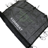Angled view of a black mesh sunshade designed for a 4-door Jeep JK. The Combat Off Road logo is prominently displayed in white across the center of the fabric. The sunshade features durable construction with reinforced edges and multiple bungee cords with hooks around the perimeter, ensuring a secure fit to the vehicle's roll bars. The material provides shade while maintaining airflow for a comfortable interior.